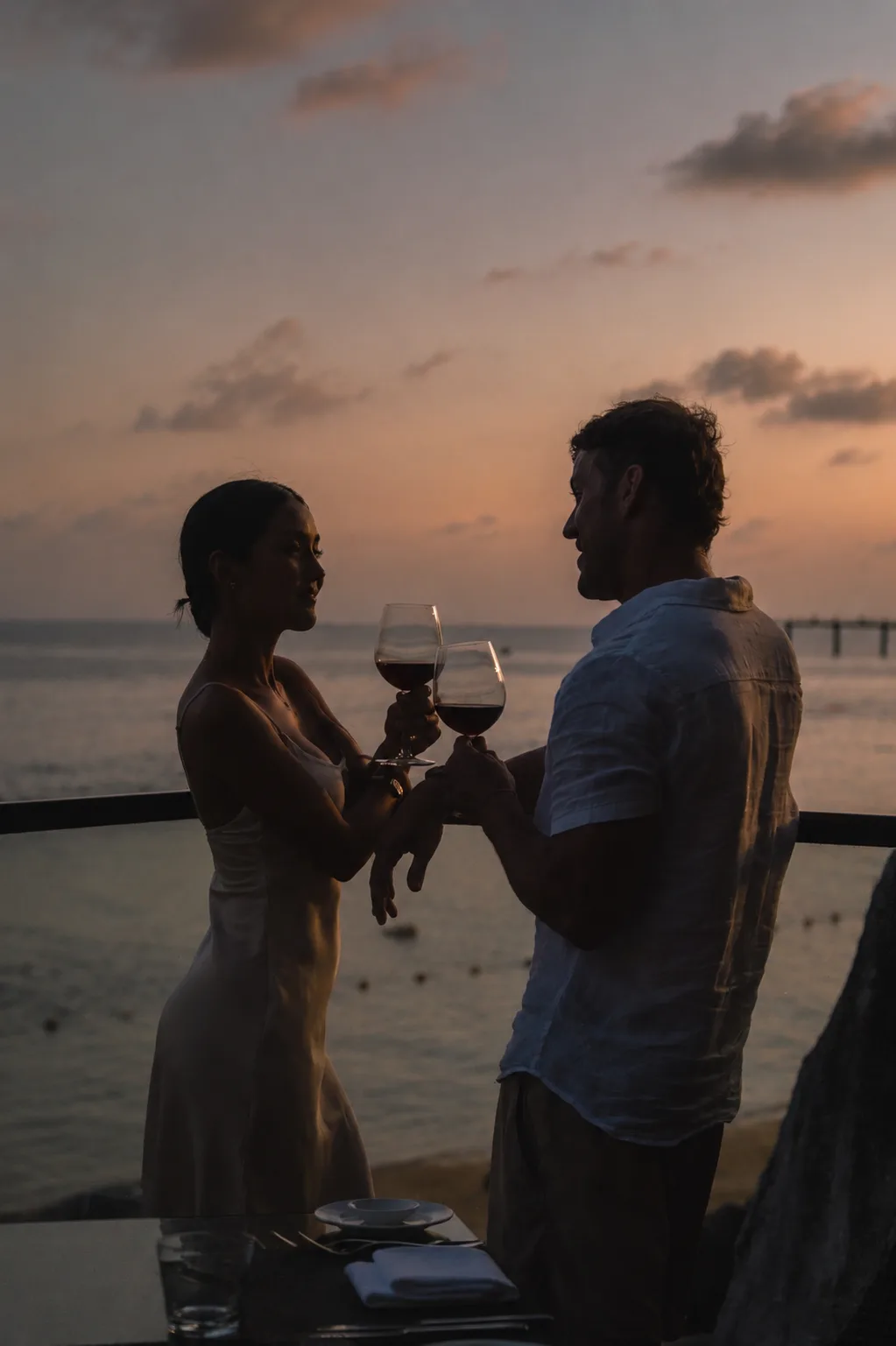Couple toasting with red wine at sunset